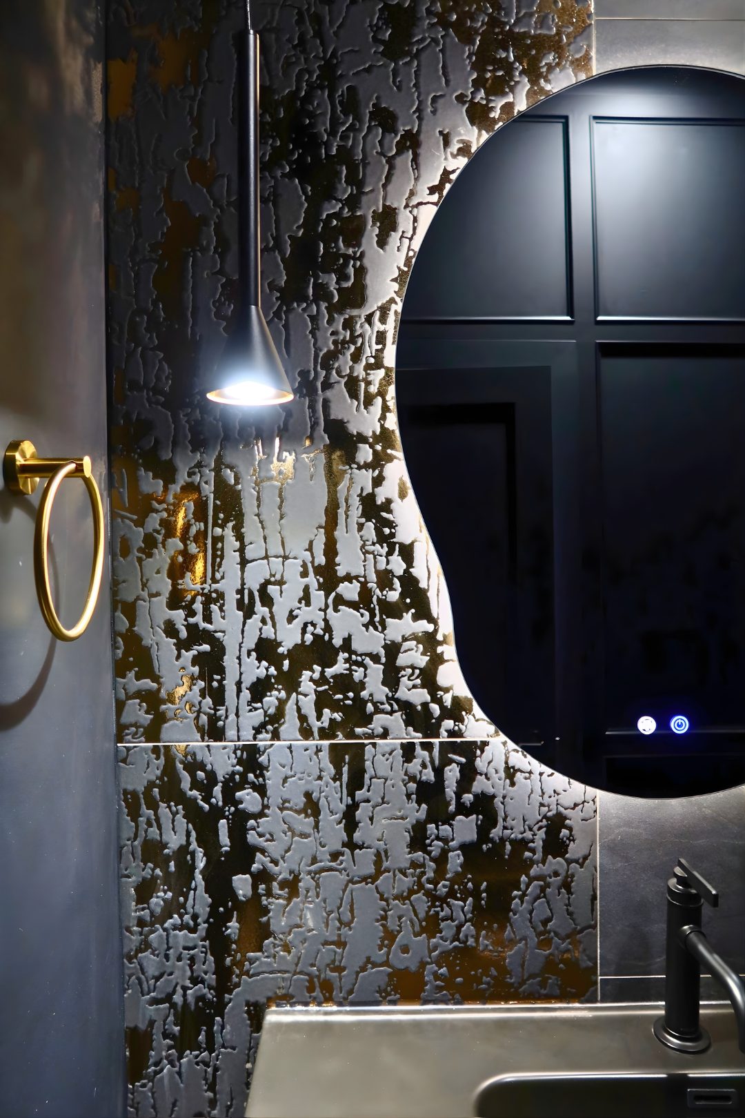 Custom powder room — designer tile and sculptural mirror